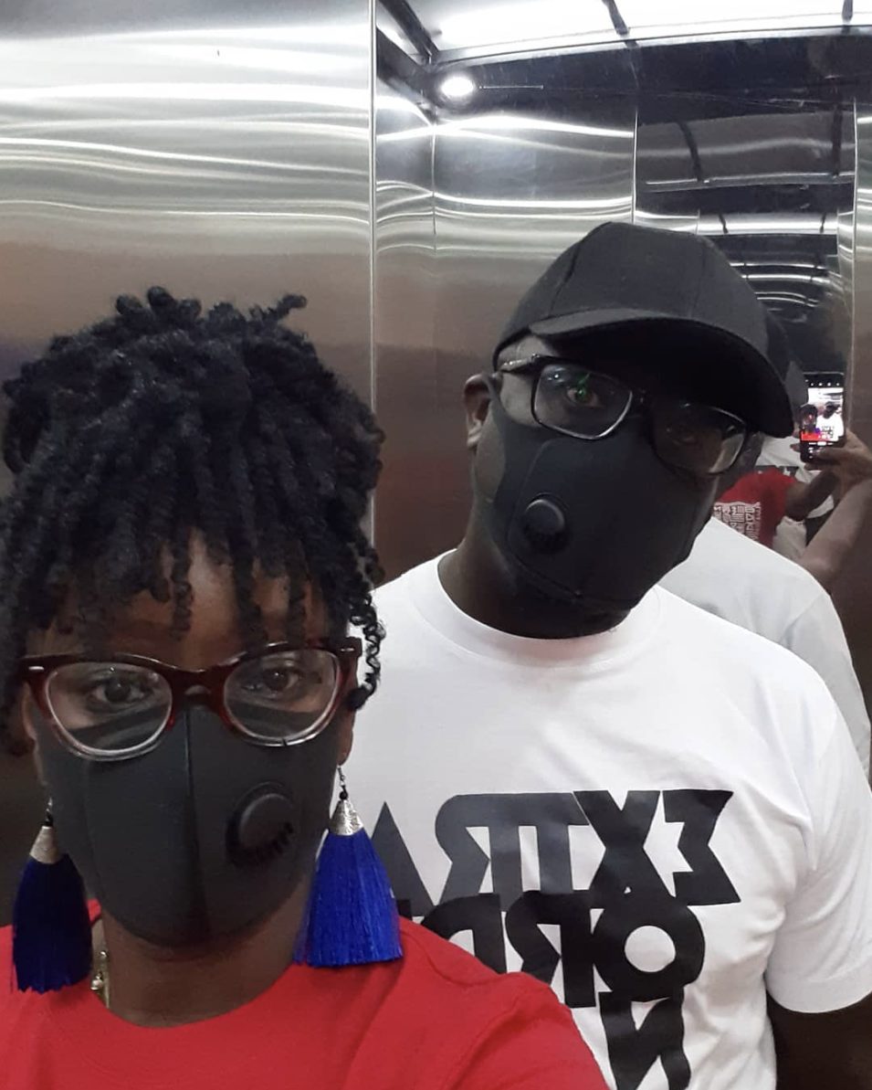 Solodified and a friend in masks in a mirrored elevator
