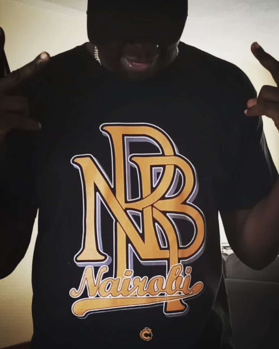 Solodified wearing the gold NBB Nairobi tee on black